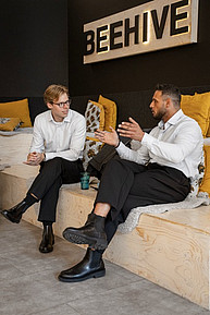 Zwei Teilnehmer im Gespraech unter dem Beehive-Logo waehrend der Networking-Pause beim Start:EUp