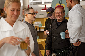 Teilnehmende und Speaker Siavash Ghassemi lachen in der Networking-Pause beim Start:EUp