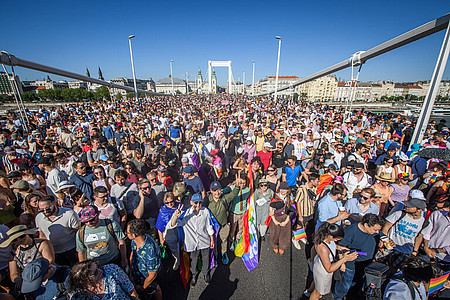 Die vielen Teilnehmden der Budapest Pride 2025 gehen über ein der bekannten Brücken Budapests. Die Brücke ist voller Menschen.